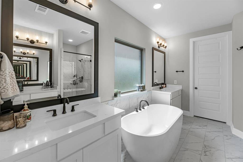 Additional view of the primary bathroom showing off fine details of the quartz counters and tile.