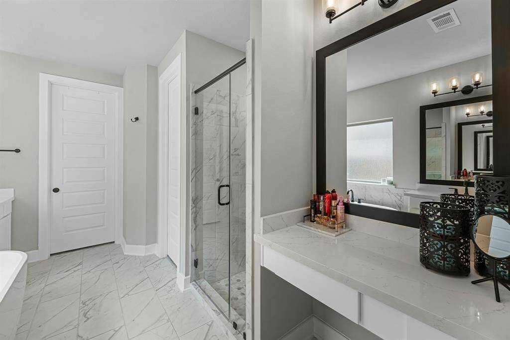 View of the separate vanity area and shower in the primary bathroom.