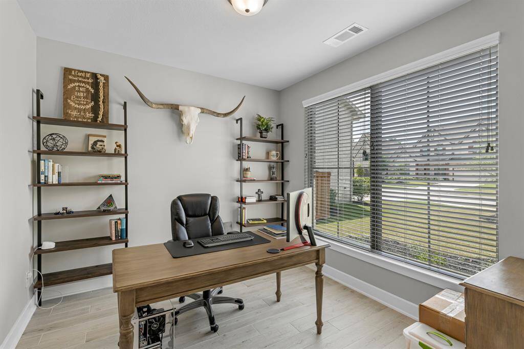Texas-sized home office located downstairs and features double glass doors and views of the front yard.