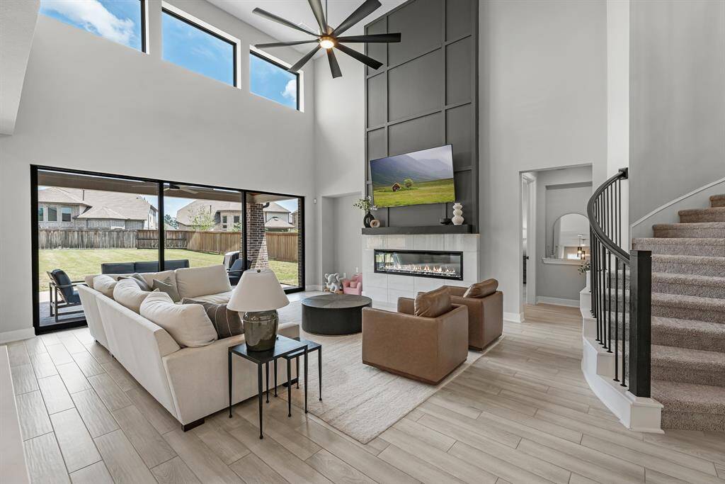 View of the living room from the kitchen area showing the central fireplace and sliding glass doors.