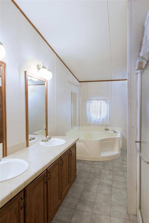 Relax in country luxury in this Primary Bathroom, adjoined to the 27' x 15' Primary Bedroom, designed for serene escapes! With rustic elegance, envision a soaking tub under a vintage chandelier, a reclaimed wood vanity, and soft tiles.