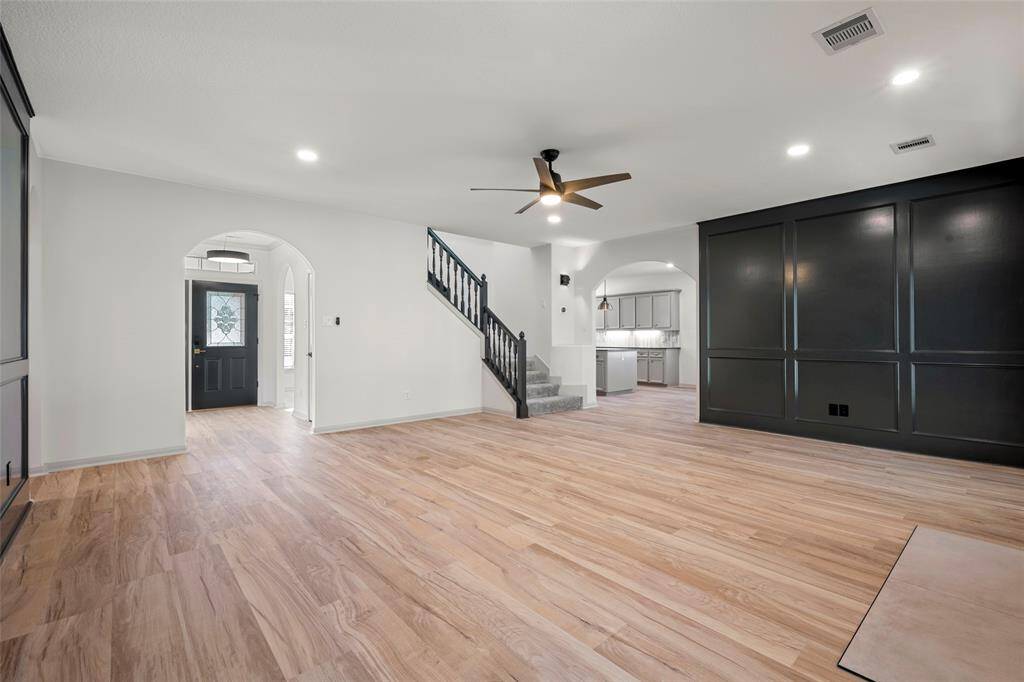 Living room features wall paneling, a fireplace and double doors to patio