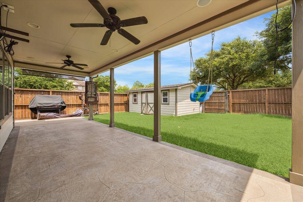 Beautiful and easy-to-maintain backyard with covered porch and shed for storage.