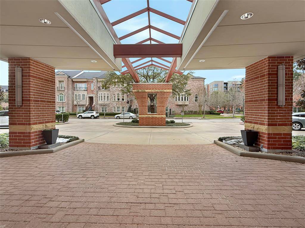 Outside Front Entry with Circular drive and guest parking at the front of the building. Gated entrance to the underground garage is to the left