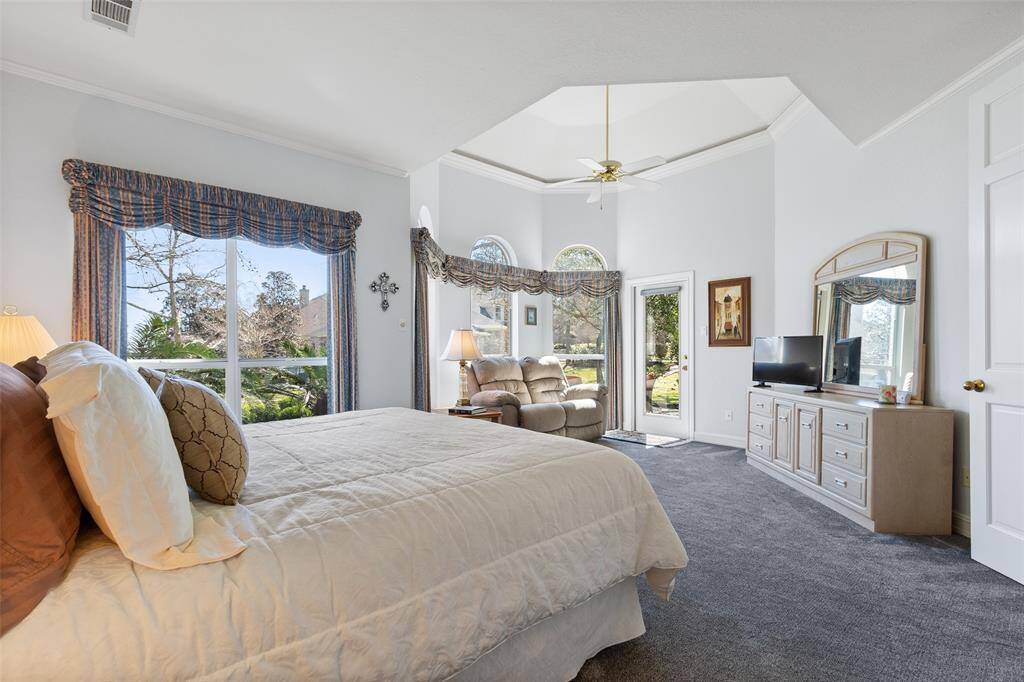 Sitting room off primary has access to the covered back patio. Enjoy early morning or wind down in the evening while watching wildlife and the water.