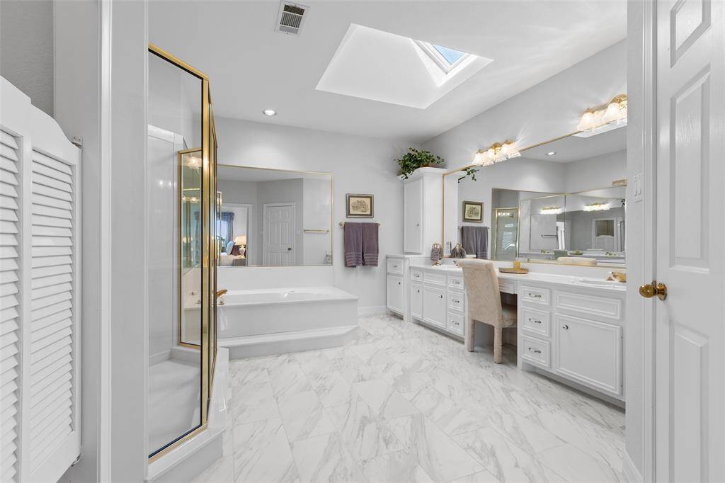 Primary bath features double sinks, soaking tub and separate oversized shower. Skylight offers natural lighting throughout the day.
