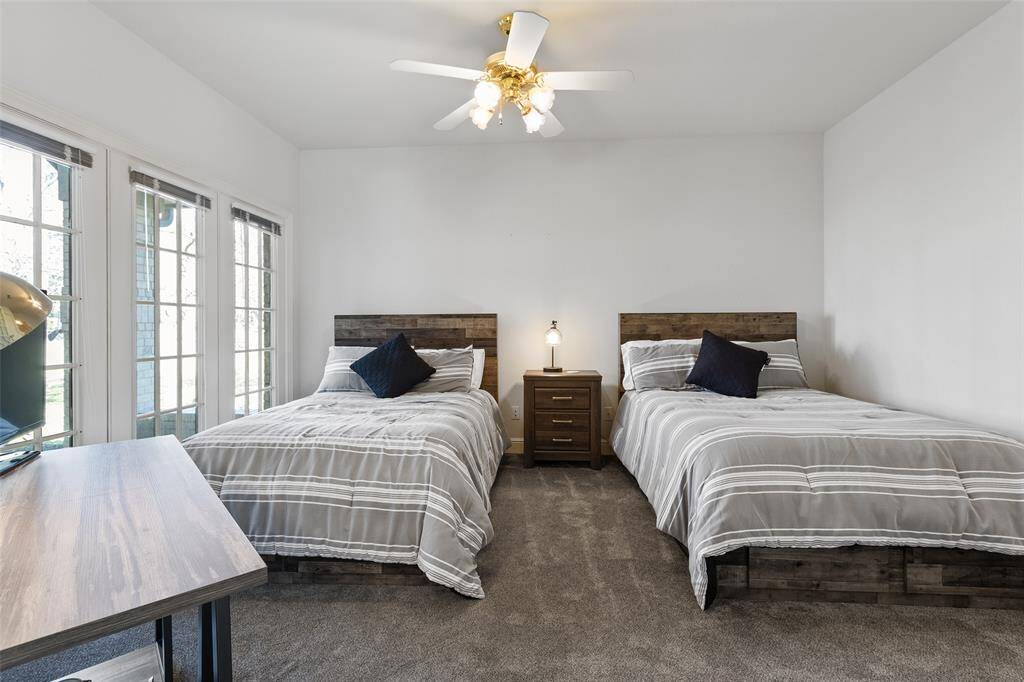 Guest bedroom faces the front yard with three large picture windows for plenty of natural light.