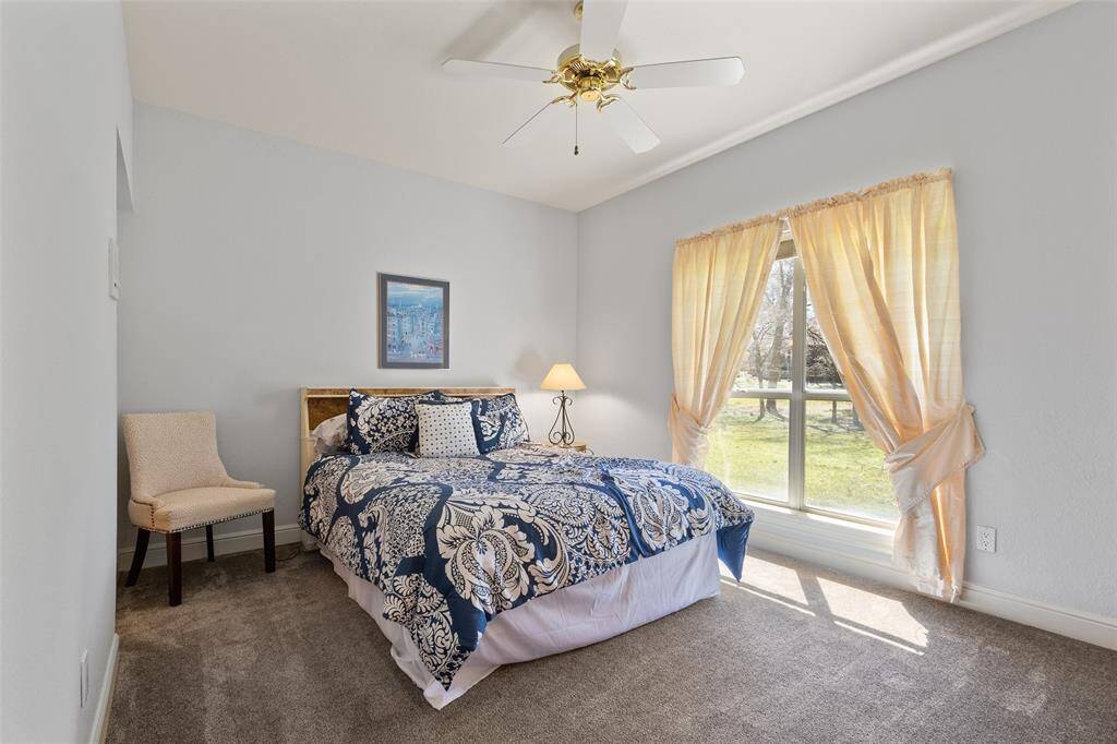 Guest bedroom overlooking the lawn. Large windows fill the space with natural light.