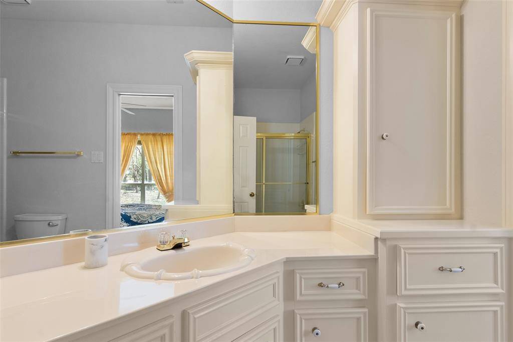 The guest bathroom offers plenty of cabinet space for storage and organization. A large walk-in shower offers space-saving convenience.