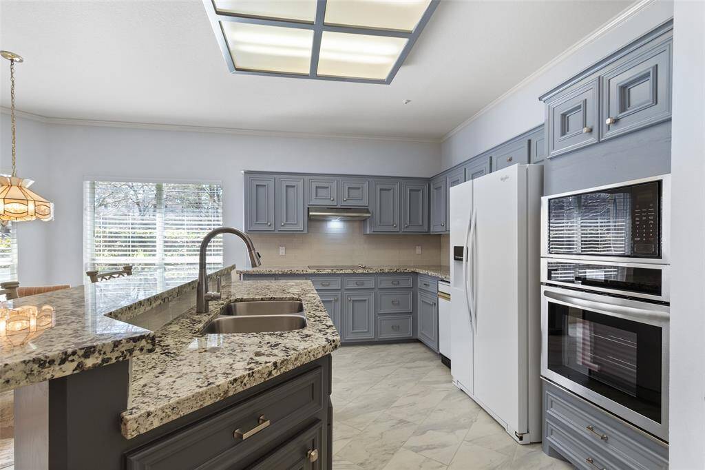 This updated galley kitchen, refreshed in the last three years, features a convenient breakfast bar and all-electric appliances. It flows seamlessly into the breakfast area, dining, and living spaces, creating an open and inviting atmosphere.