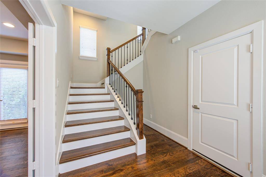 This roomy bedroom has a ceiling fan, tray ceiling and the lovely wood floors.