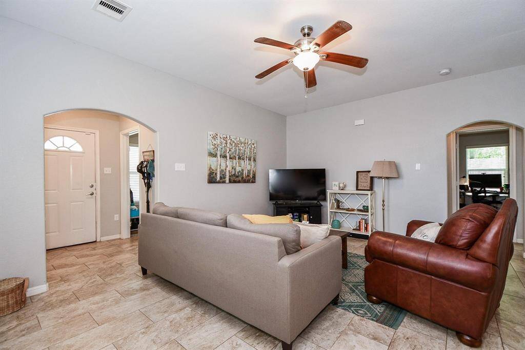 Living room with neutral hues and a modern ceiling fan.