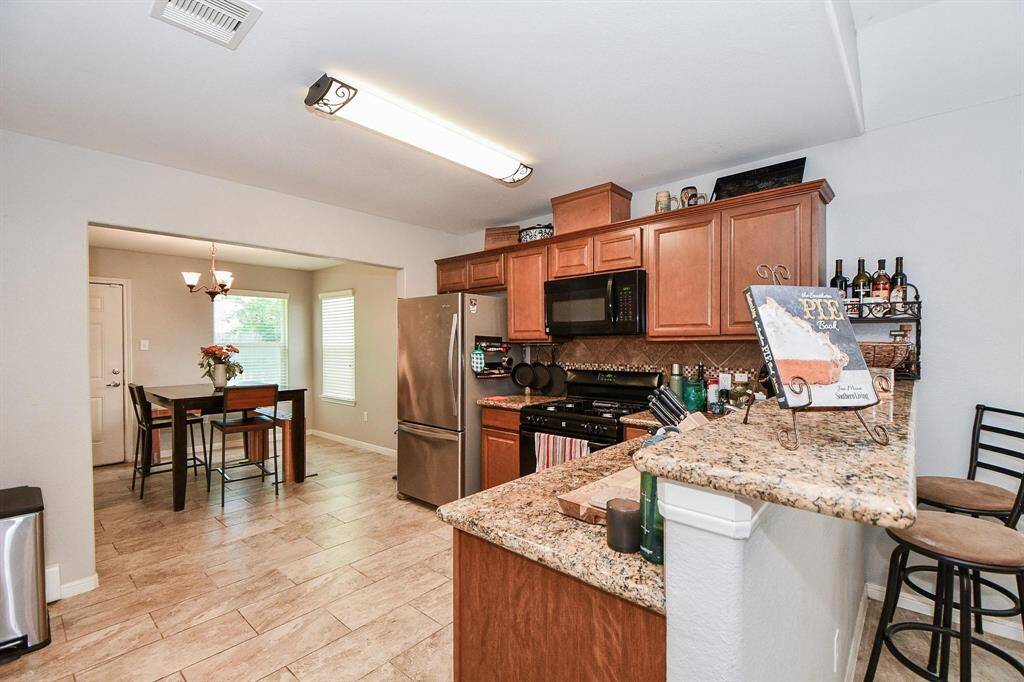 A bright, well-lit kitchen next to the dining area, perfect for cooking and entertaining in style.