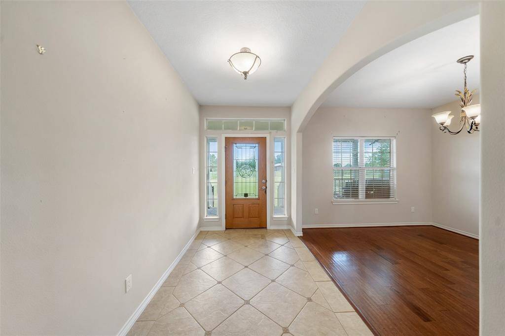 Tile flooring and natural light highlight this welcoming foyer, with a decorative glass front door adding charm and curb appeal from within.
