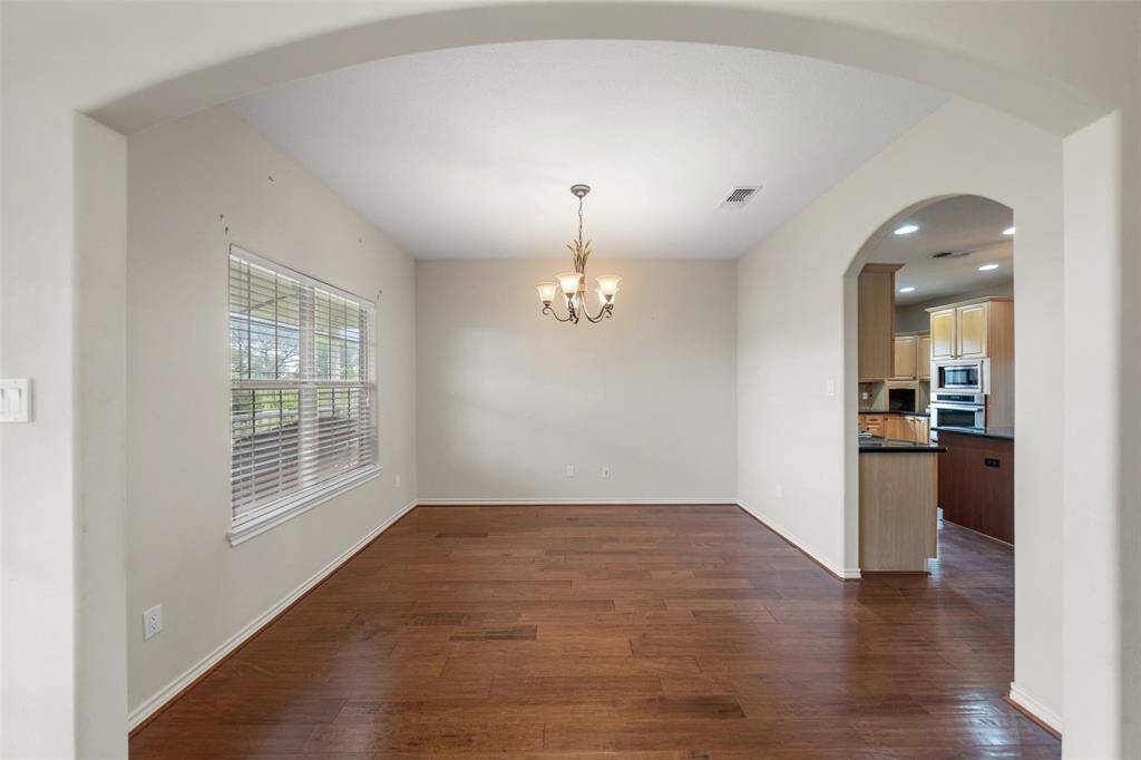 Just off the kitchen, this dedicated dining space showcases hardwood floors and an arched entryway—ideal for formal meals or casual gatherings.