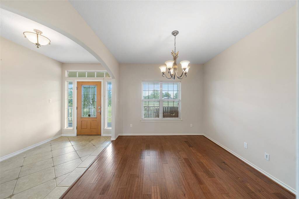 A bright entryway with tile flooring and sidelights welcomes you into the home, offering a seamless flow into a flexible front room with wood flooring.
