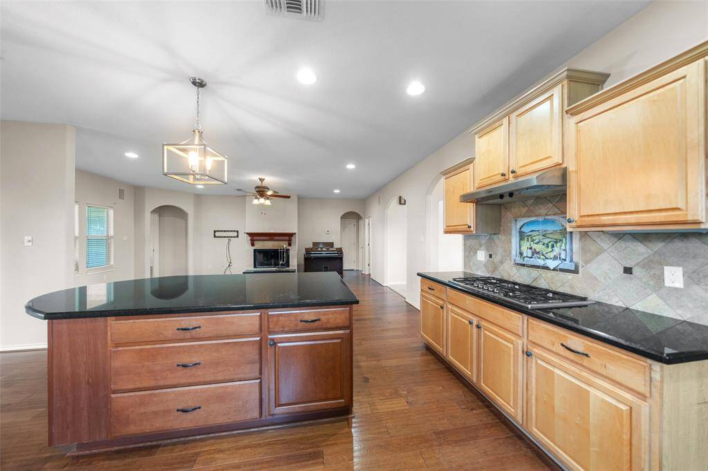 A spacious island with rich wood tones offers extra prep space, storage, and seating options—perfect for both cooking and gathering.