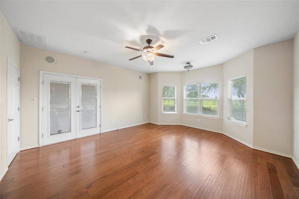 French doors in the primary suite open directly to the back porch, blending indoor luxury with outdoor access and scenic views.