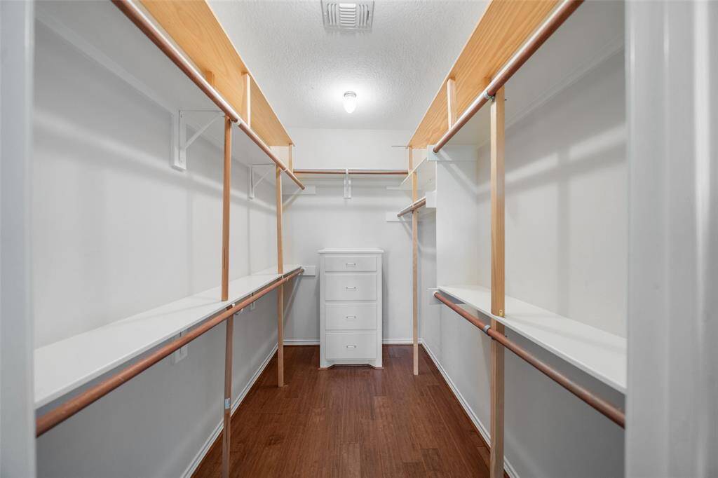 A generous walk-in closet with built-in drawers and double hanging racks offers excellent storage and organization.