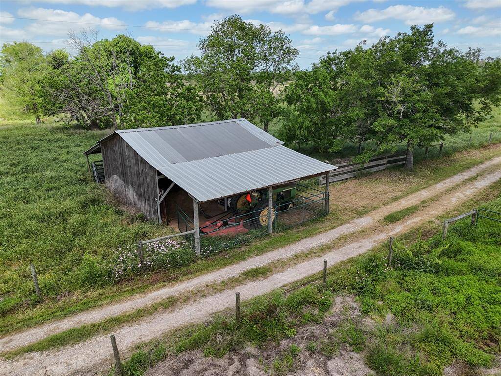 Barn with gated lean-to and equipment storage—ready for agricultural operations or hobby farming.