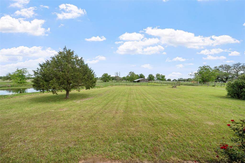Open, level green space behind the home—ideal for recreation, gardening, or future outdoor living expansions.