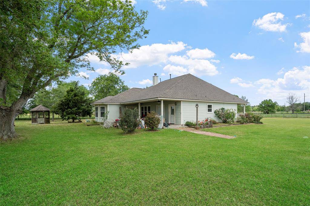 Enjoy the peaceful backyard surrounded by mature trees and open space, with a cozy gazebo tucked under the shade.