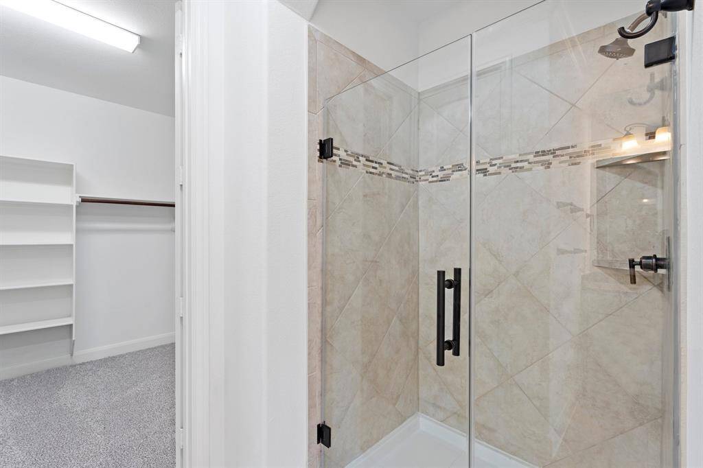 The primary bedroom also features a spacious walk-in shower and a generously sized walk-in closet, offering both comfort and convenience for your daily routine.
