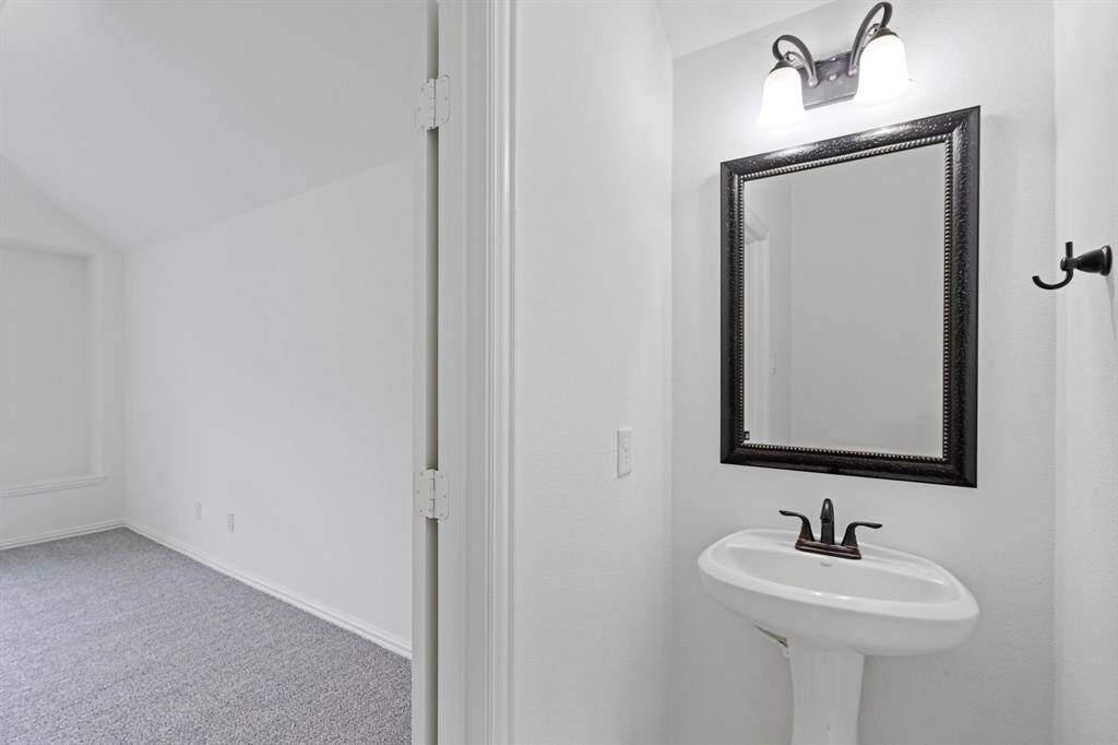 This convenient half bathroom is perfectly located next to the game room, offering easy access for both guests and family.