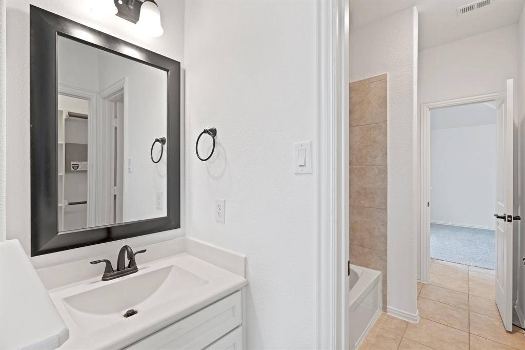 This spacious bedroom features a bright window for natural light, a high sloped ceiling, and a ceiling fan for added comfort and air circulation. *Virtually Staged*
