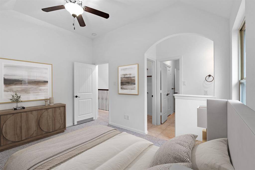 This spacious bedroom features a bright window for natural light, a high sloped ceiling, and a ceiling fan for added comfort and air circulation. *Virtually Staged*