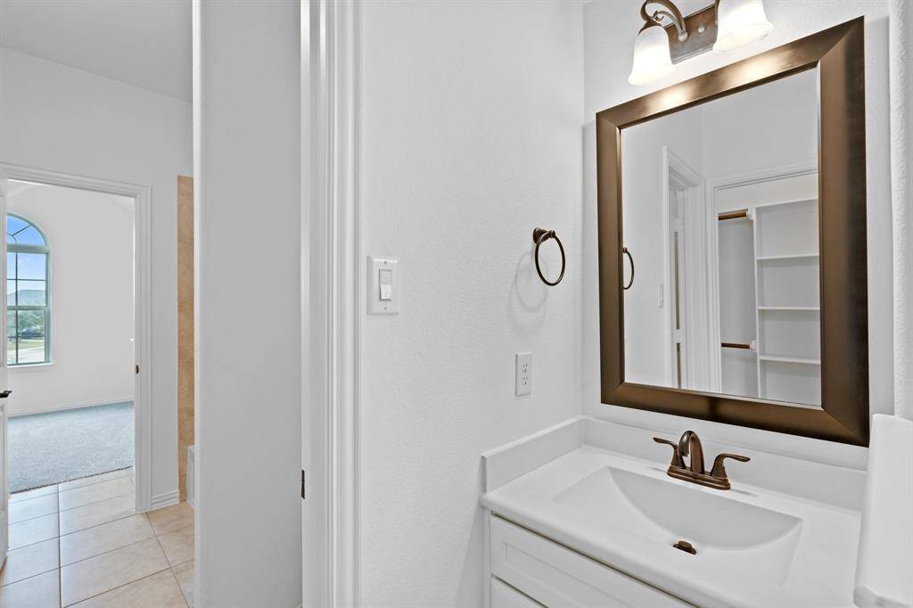 This bedroom also provides access to the shared bathroom and includes a private sink vanity, offering both convenience and personal space.