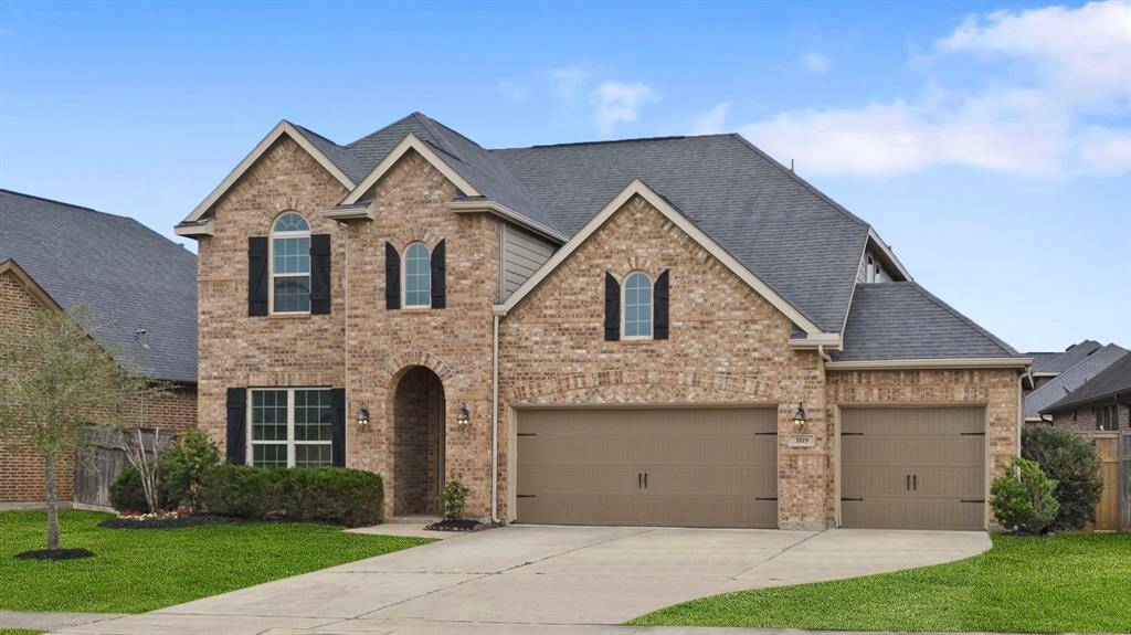 This home boasts a lush green lawn, elegant landscaping, a spacious double-wide driveway, and a convenient 3-car garage, offering both curb appeal and ample parking space.