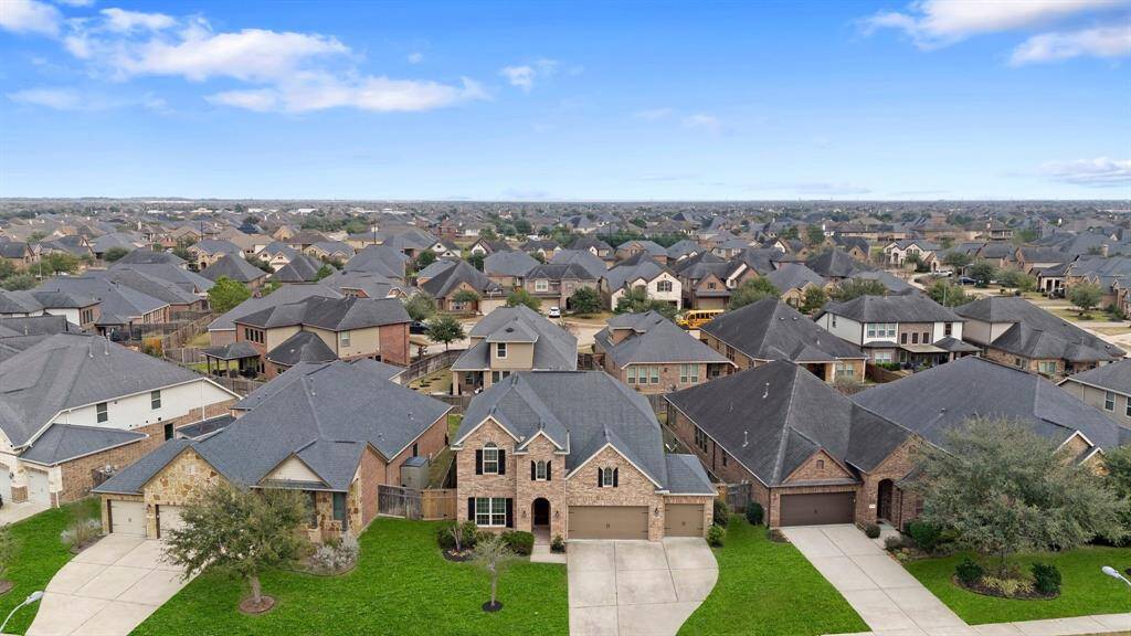 Take in the stunning aerial view of the front of this home, offering a glimpse of the beautiful neighborhood and its inviting surroundings.