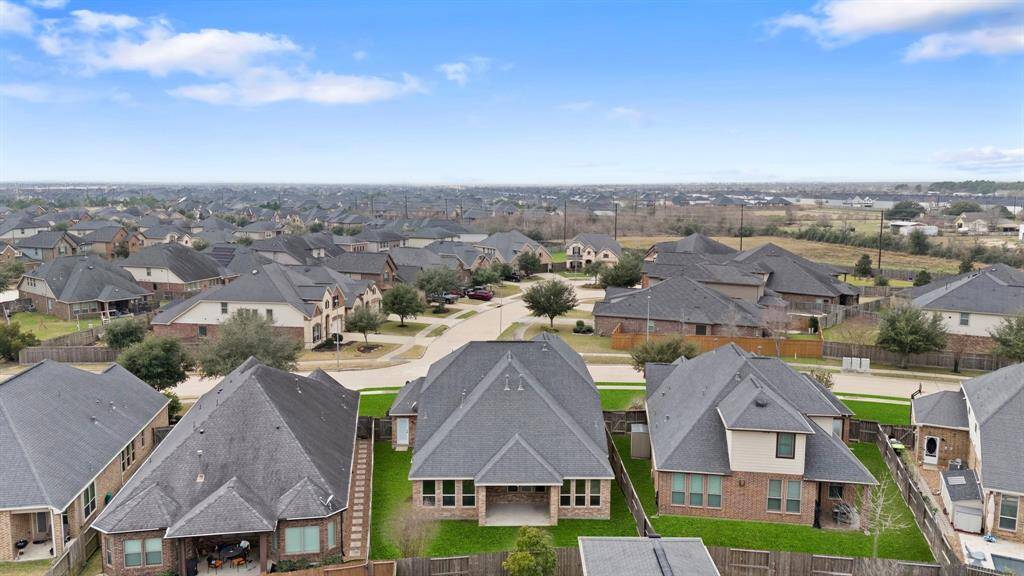 Enjoy the aerial view of the back of the home, showcasing the spacious backyard and the tranquil neighborhood that surrounds it.