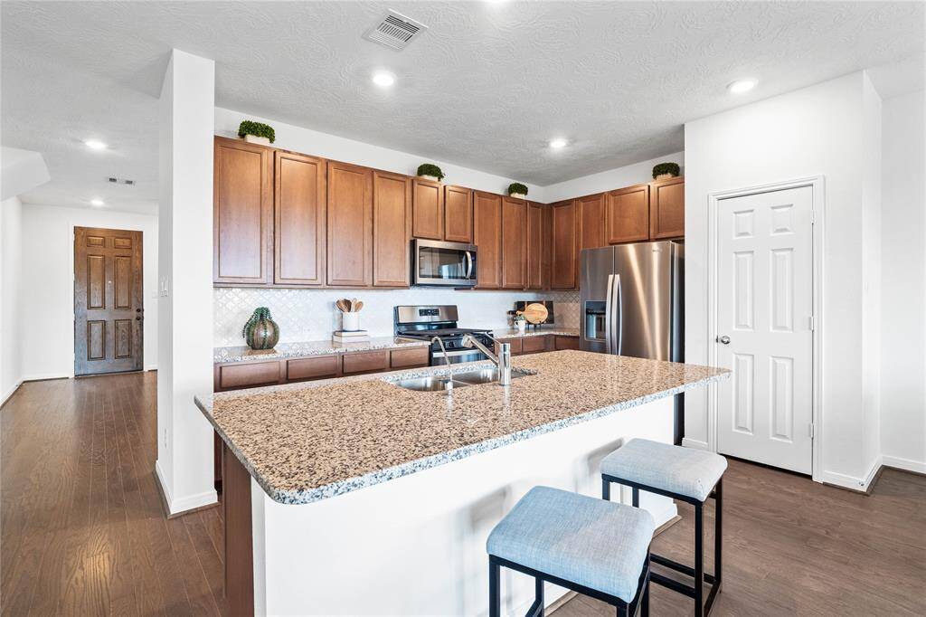 Additional view of this beautiful kitchen featuring a granite island and extended bar top.