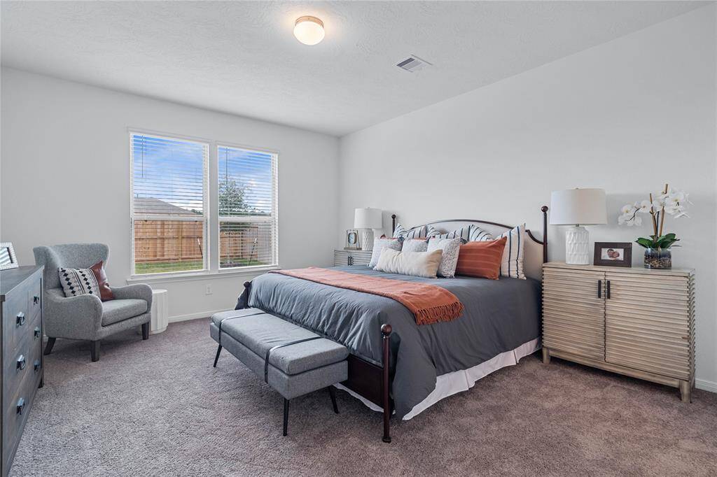 Come and unwind after a long day in this magnificent primary suite! This spacious room features plush carpet, warm paint, high ceilings and large windows with privacy blinds.
