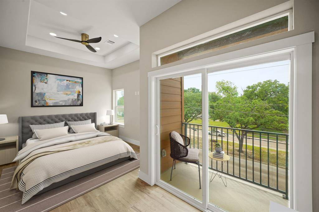 Virtually Staged: Unwind after a long day in this incredible primary bedroom! Featuring vinyl plank floors, a tray ceiling with a ceiling fan, and a private balcony.