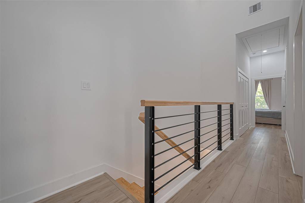 Modern staircase with warm wood treads and horizontal black railings, adding architectural interest and clean lines.