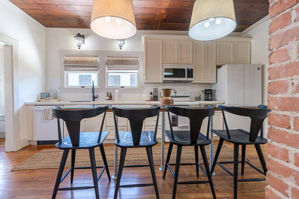 Front House: Chef's eat-in kitchen features lengthy quartz countertops and 42" cabinets with crown molding