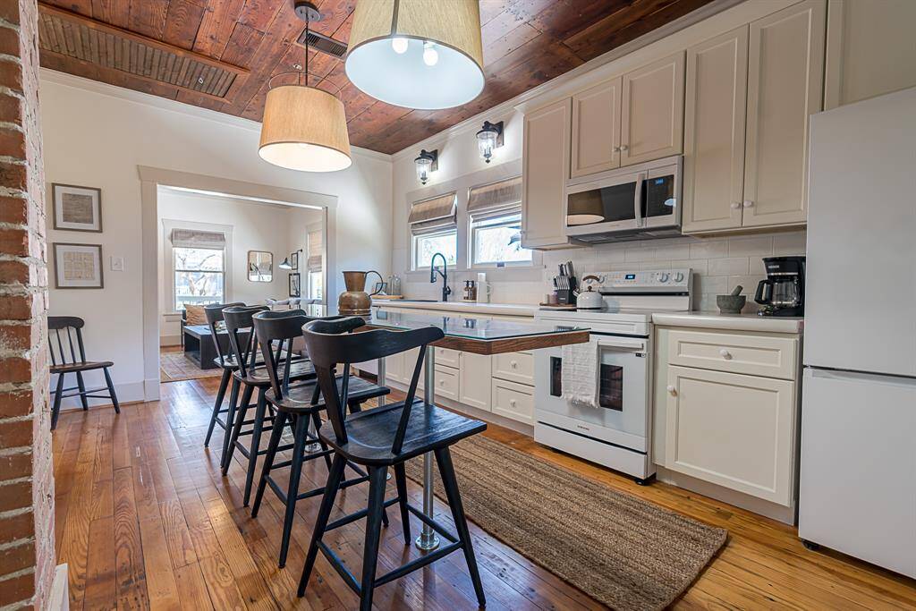 Front House: Chef's eat-in kitchen features lengthy quartz countertops and 42" cabinets with crown molding