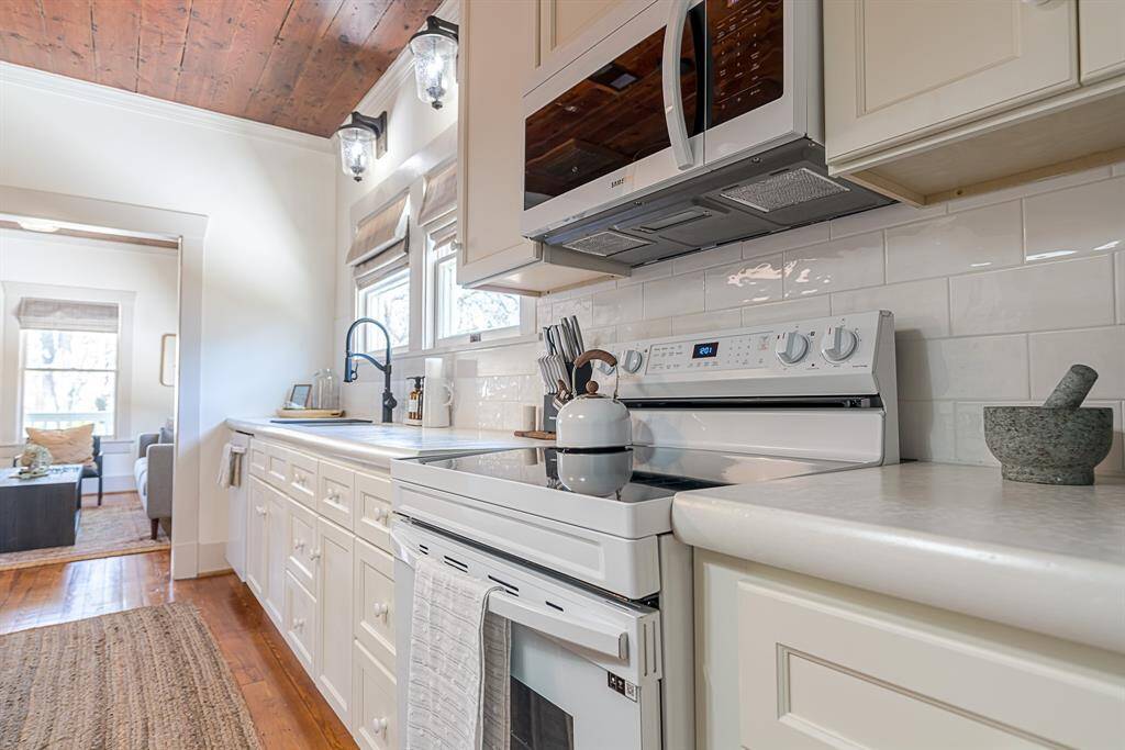 Front House: Chef's eat-in kitchen features lengthy quartz countertops and 42" cabinets with crown molding