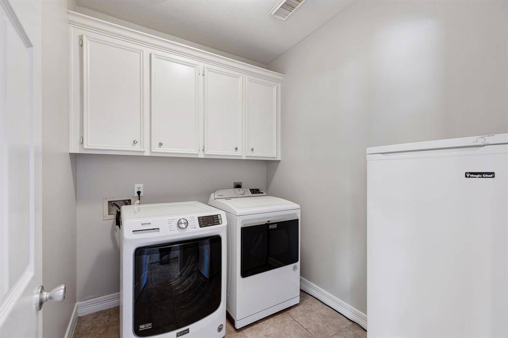 Laundry may be an ongoing chore, but in this home, it will be an easy and fun one! Featuring mounted cabinetry, the spacious laundry room has an area for storing essentials and plenty of room.