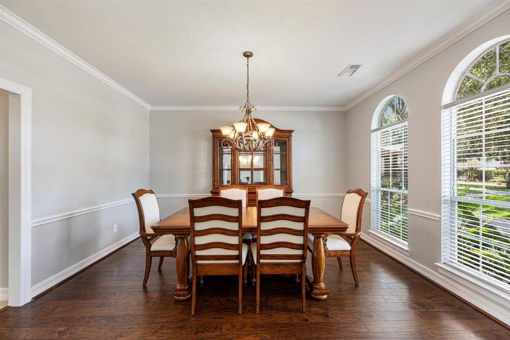 Softly curving arches enhance the entryways with a polished touch. Invite friends and family over for holiday dinners in your formal dining room, which includes chair rails, crown molding, and a graceful chandelier.