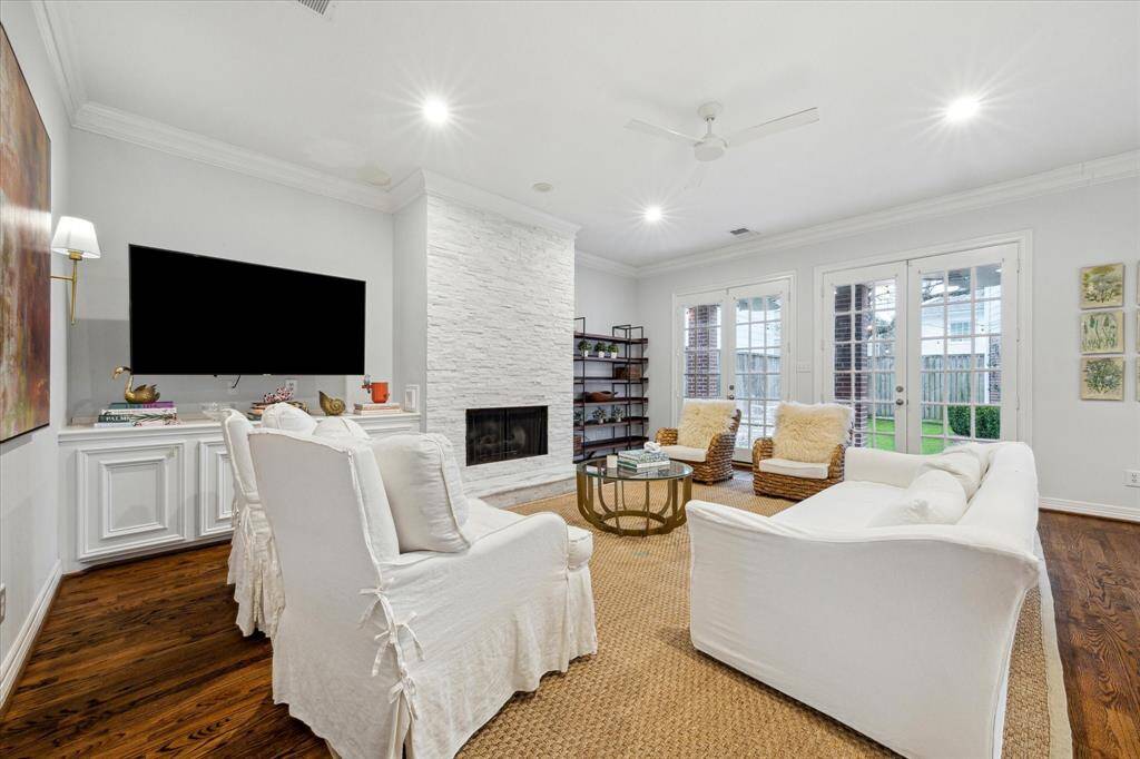 Living room area with French doors offering views of the turfed backyard and filling the space with abundant natural light.