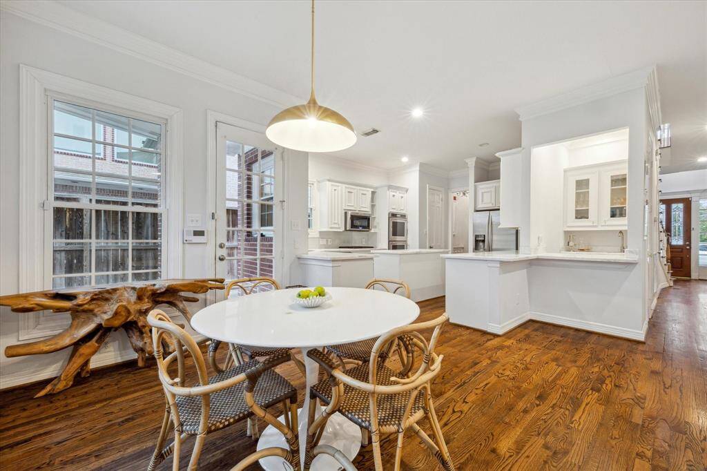 Kitchen nook surrounded by windows, offering views of the kitchen and living space, perfect for family time.