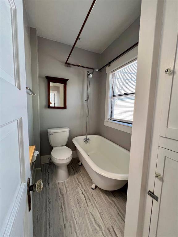 The bathroom features a classic clawfoot tub and shower combo.