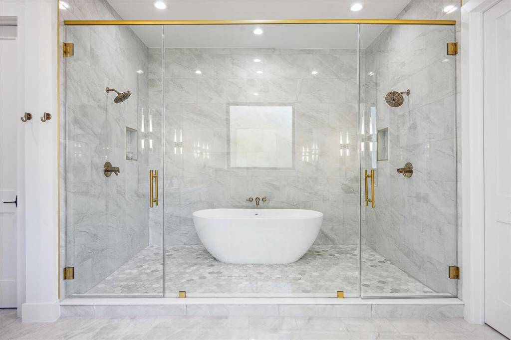 Freestanding soaking tub in large primary wet room