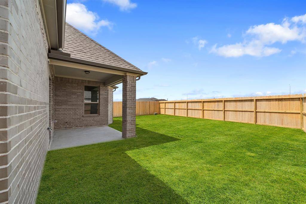 The covered patio is generously sized, providing ample space for various outdoor activities.