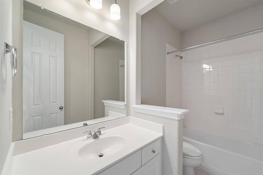The secondary bath features tile flooring, white cabinetry and light countertops and a shower/tub combo. Perfect for accommodating any visiting family and friends.