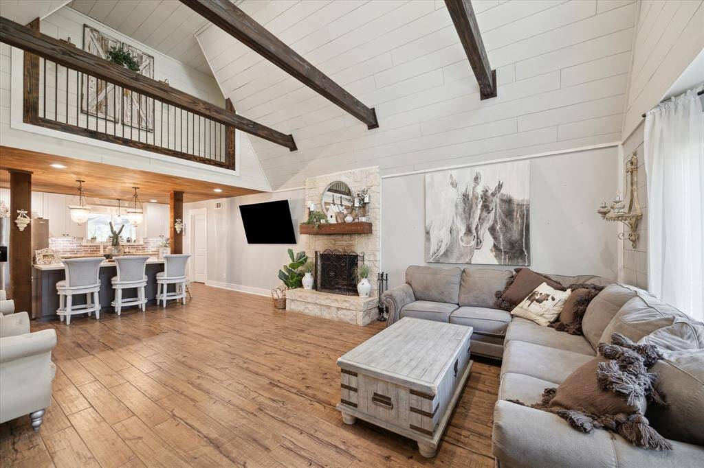 The living room showcases Rustin wood beams and soaring high ceilings.